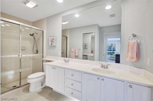 bathroom with tile patterned floors, toilet, vanity, and walk in shower