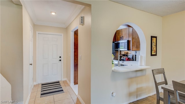 entryway featuring light tile flooring and ornamental molding