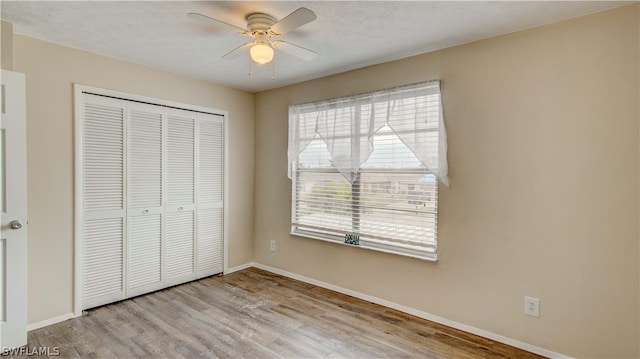 unfurnished bedroom featuring a closet, ceiling fan, and light wood-type flooring