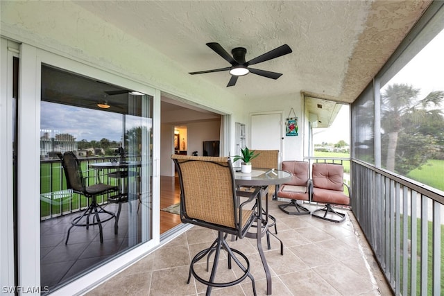 sunroom / solarium featuring a wealth of natural light and ceiling fan