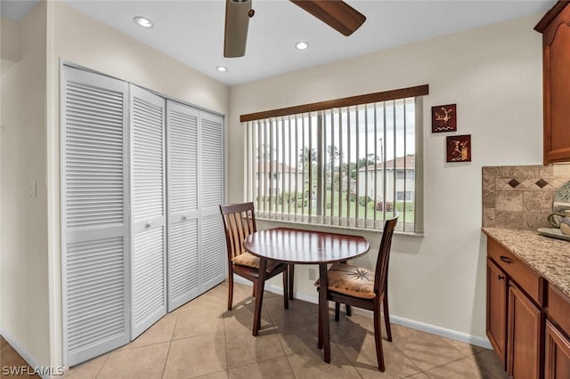 tiled dining space featuring ceiling fan