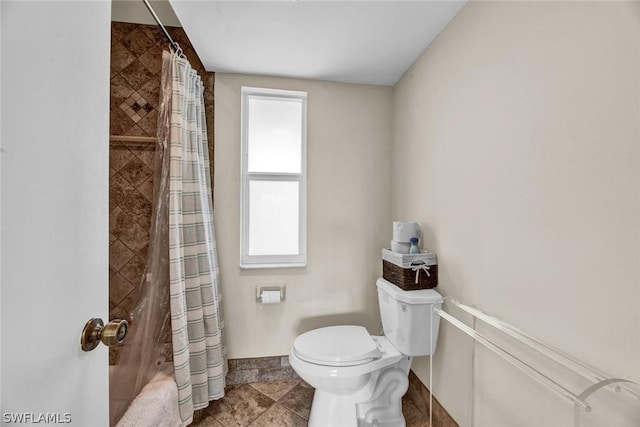 bathroom featuring shower / bath combo and toilet