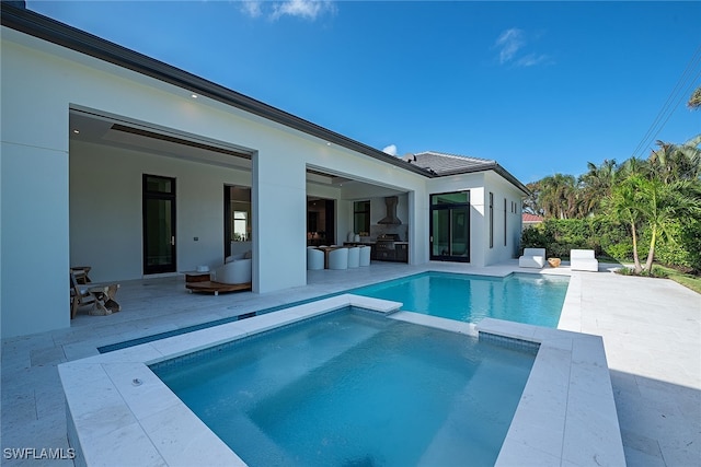 view of swimming pool with an outdoor living space, an in ground hot tub, and a patio area