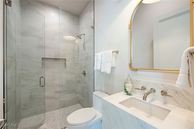 bathroom with vanity, toilet, and a shower with shower door