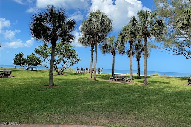 view of home's community with a lawn and a water view