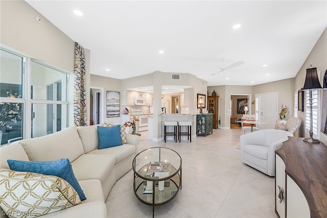 living room featuring light tile floors and ceiling fan