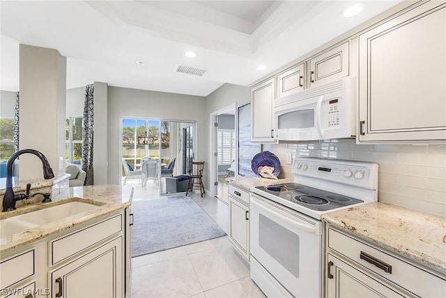 kitchen featuring light tile floors, light stone countertops, tasteful backsplash, white appliances, and sink