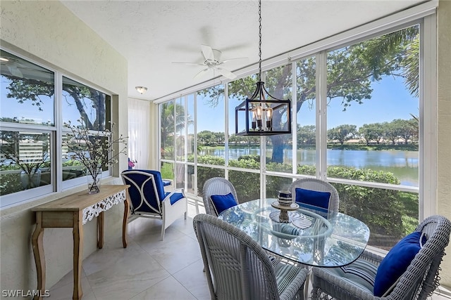 sunroom with a water view, a healthy amount of sunlight, and ceiling fan with notable chandelier