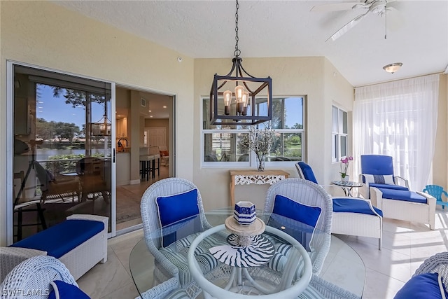 dining space featuring a textured ceiling, ceiling fan with notable chandelier, and light tile flooring