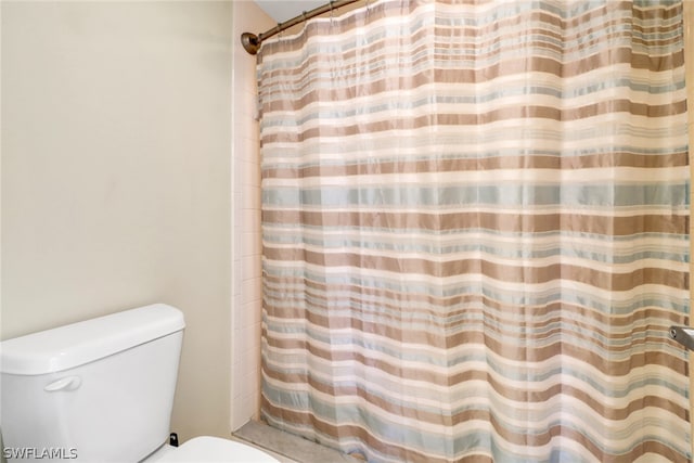 bathroom with toilet and curtained shower