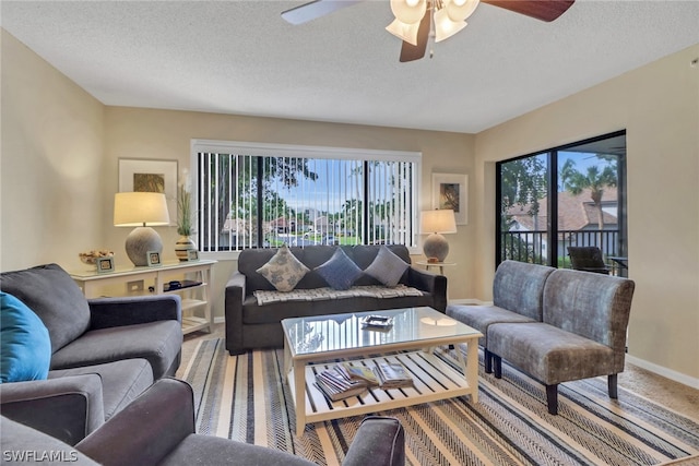 carpeted living room with a textured ceiling, plenty of natural light, and ceiling fan
