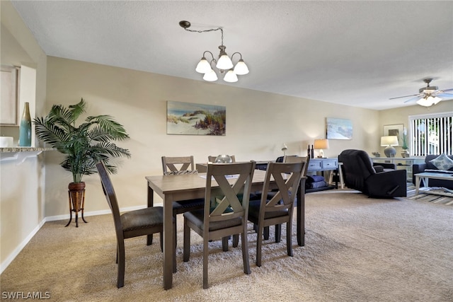 carpeted dining area with a textured ceiling and ceiling fan with notable chandelier