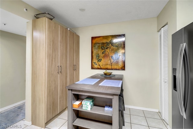 dining area featuring light tile patterned flooring and a textured ceiling