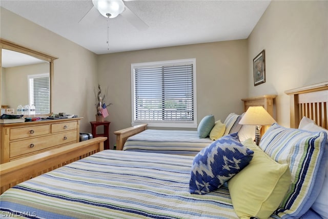 bedroom with ceiling fan and a textured ceiling