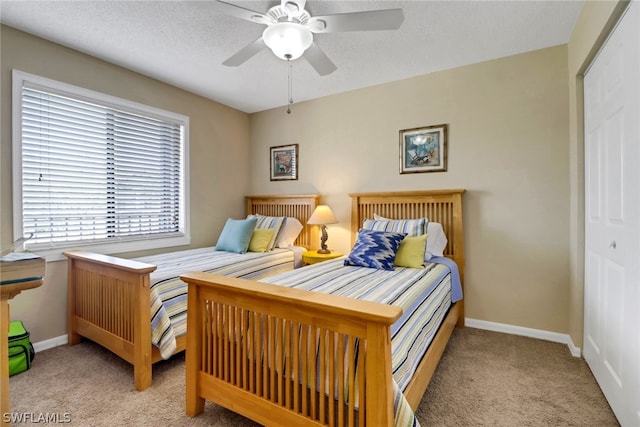carpeted bedroom with a textured ceiling, a closet, and ceiling fan