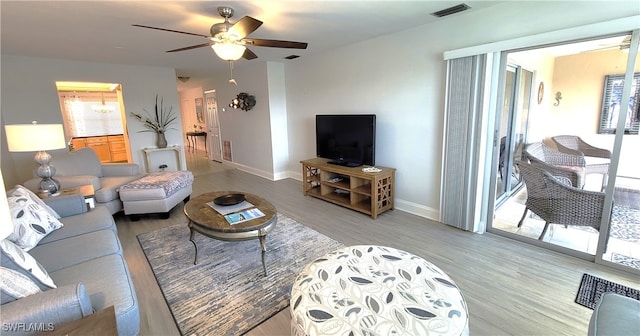 living room featuring ceiling fan and light hardwood / wood-style floors