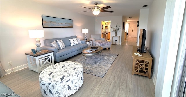 living room featuring light wood-type flooring and ceiling fan