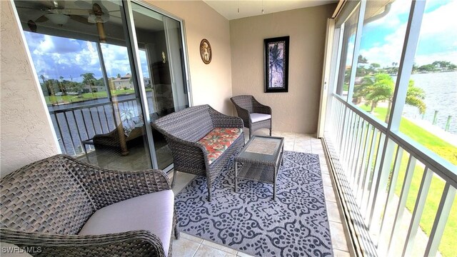 balcony featuring a water view and ceiling fan