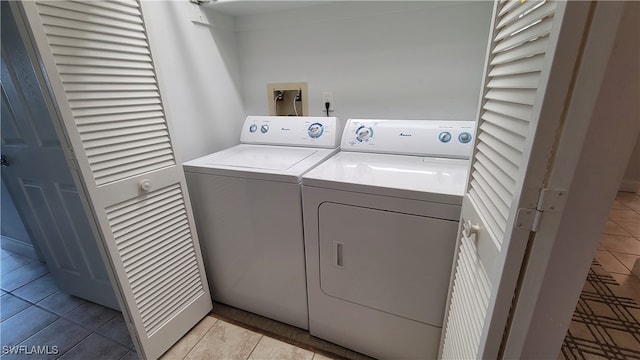 washroom featuring light tile patterned floors and washer and clothes dryer