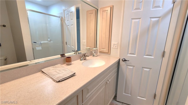 bathroom featuring vanity, toilet, and an enclosed shower