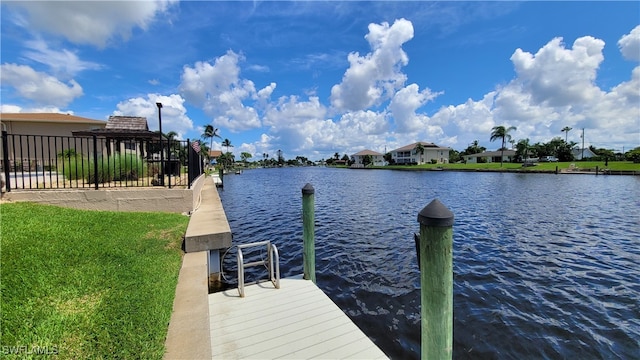 view of dock with a water view and a yard