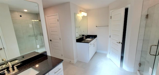 bathroom with a shower with shower door and vanity