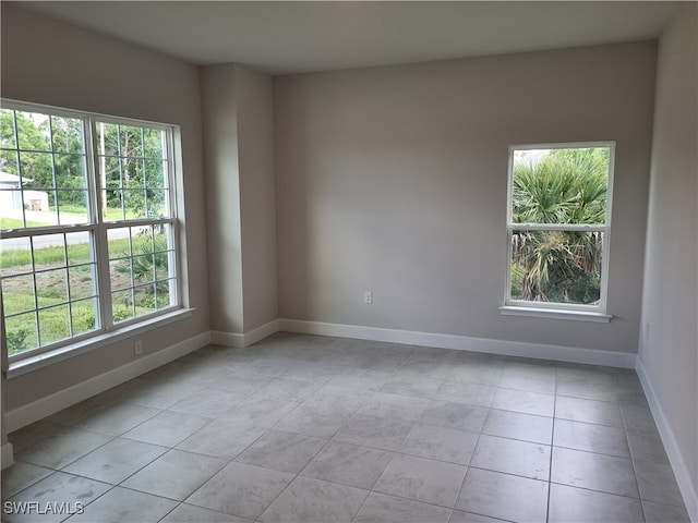 tiled empty room featuring a wealth of natural light