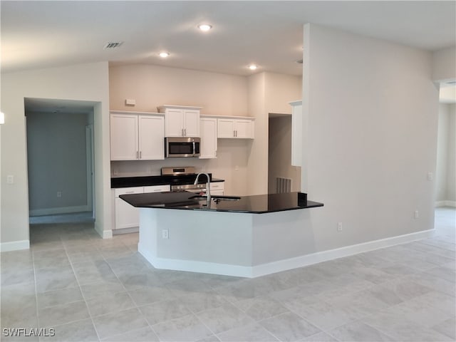 kitchen featuring white cabinetry, stainless steel appliances, sink, vaulted ceiling, and light tile patterned flooring