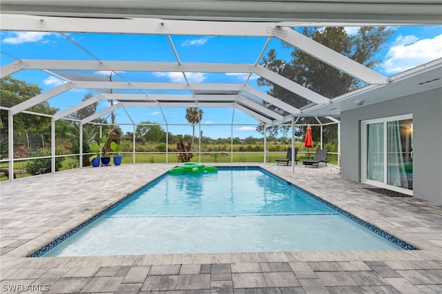 view of pool with a patio area and glass enclosure