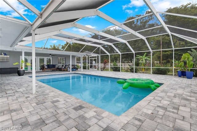 view of swimming pool with an outdoor hangout area, a patio area, and glass enclosure