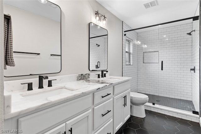 bathroom featuring toilet, tile patterned flooring, a shower with door, and vanity