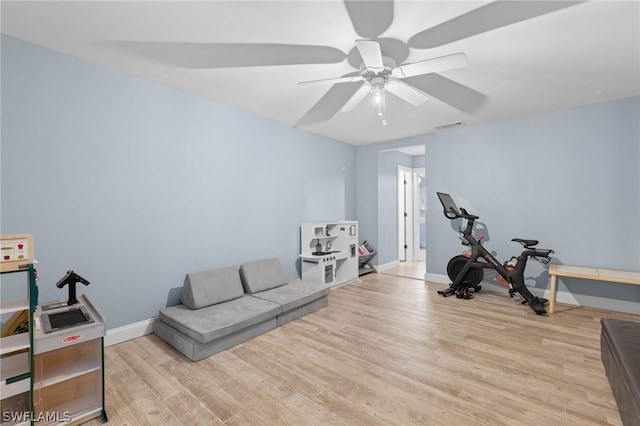 exercise area featuring ceiling fan and light hardwood / wood-style flooring