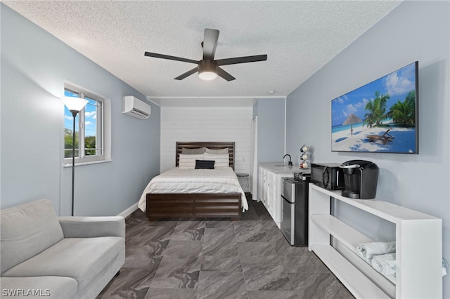 bedroom with a wall unit AC, ceiling fan, a textured ceiling, and stainless steel fridge