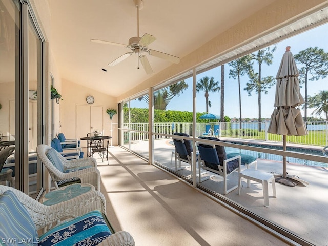 sunroom / solarium featuring ceiling fan, a water view, and vaulted ceiling