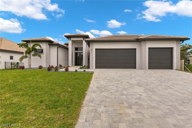 prairie-style house featuring a front lawn and a garage