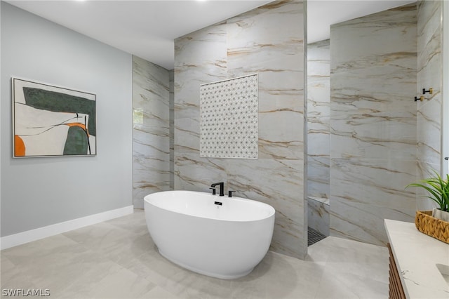 bathroom featuring a tub, tile walls, tile floors, and vanity