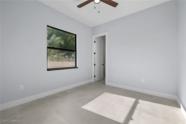 spare room with ceiling fan and light tile flooring