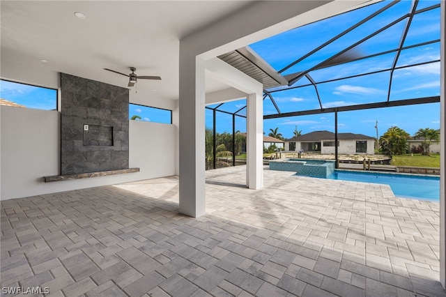 view of pool featuring a patio, glass enclosure, and ceiling fan