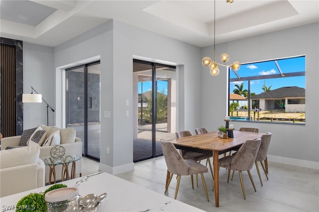 tiled dining space with an inviting chandelier, plenty of natural light, and a tray ceiling