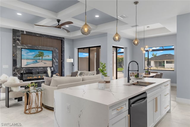 kitchen featuring white cabinetry, a kitchen island with sink, a high end fireplace, and stainless steel dishwasher