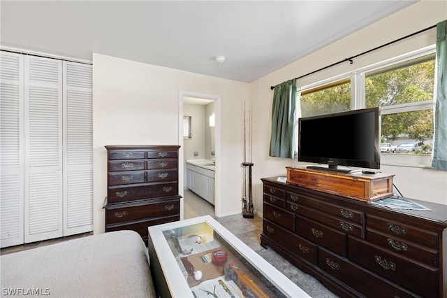 tiled bedroom featuring a closet and ensuite bathroom