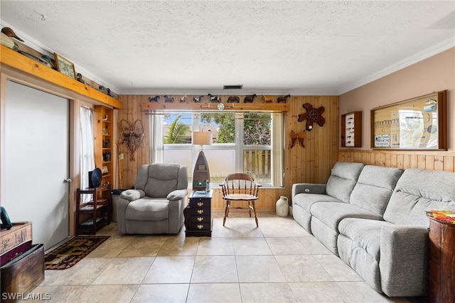 tiled living room with a textured ceiling, wooden walls, and ornamental molding