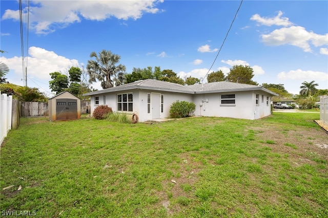 rear view of house featuring a lawn and a storage shed