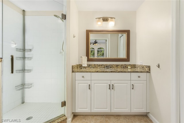 bathroom with tile flooring, walk in shower, and vanity