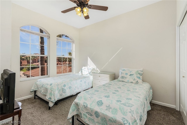 bedroom featuring dark carpet, a closet, and ceiling fan