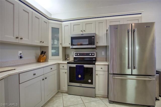 kitchen featuring stainless steel appliances, white cabinetry, and light tile patterned floors