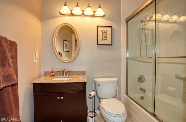 full bathroom featuring enclosed tub / shower combo, vanity, and toilet