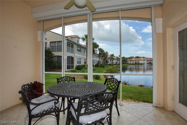 sunroom with a water view and ceiling fan