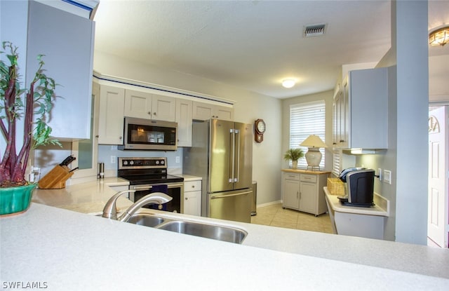 kitchen with stainless steel appliances, sink, and light tile patterned floors