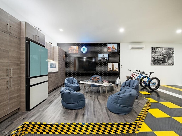 recreation room featuring an AC wall unit and light wood-type flooring